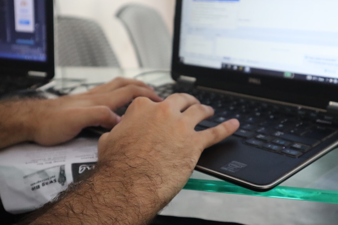 a man is typing on a laptop computer
