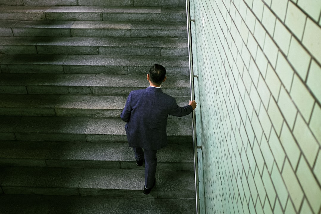 A man in a suit walking up a flight of stairs